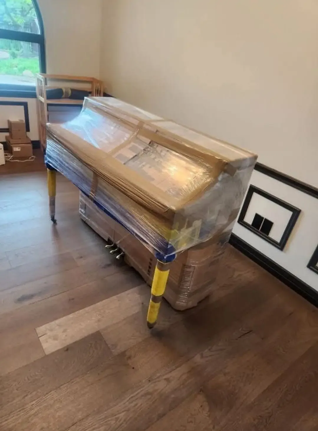 Wrapped upright piano prepared for moving
