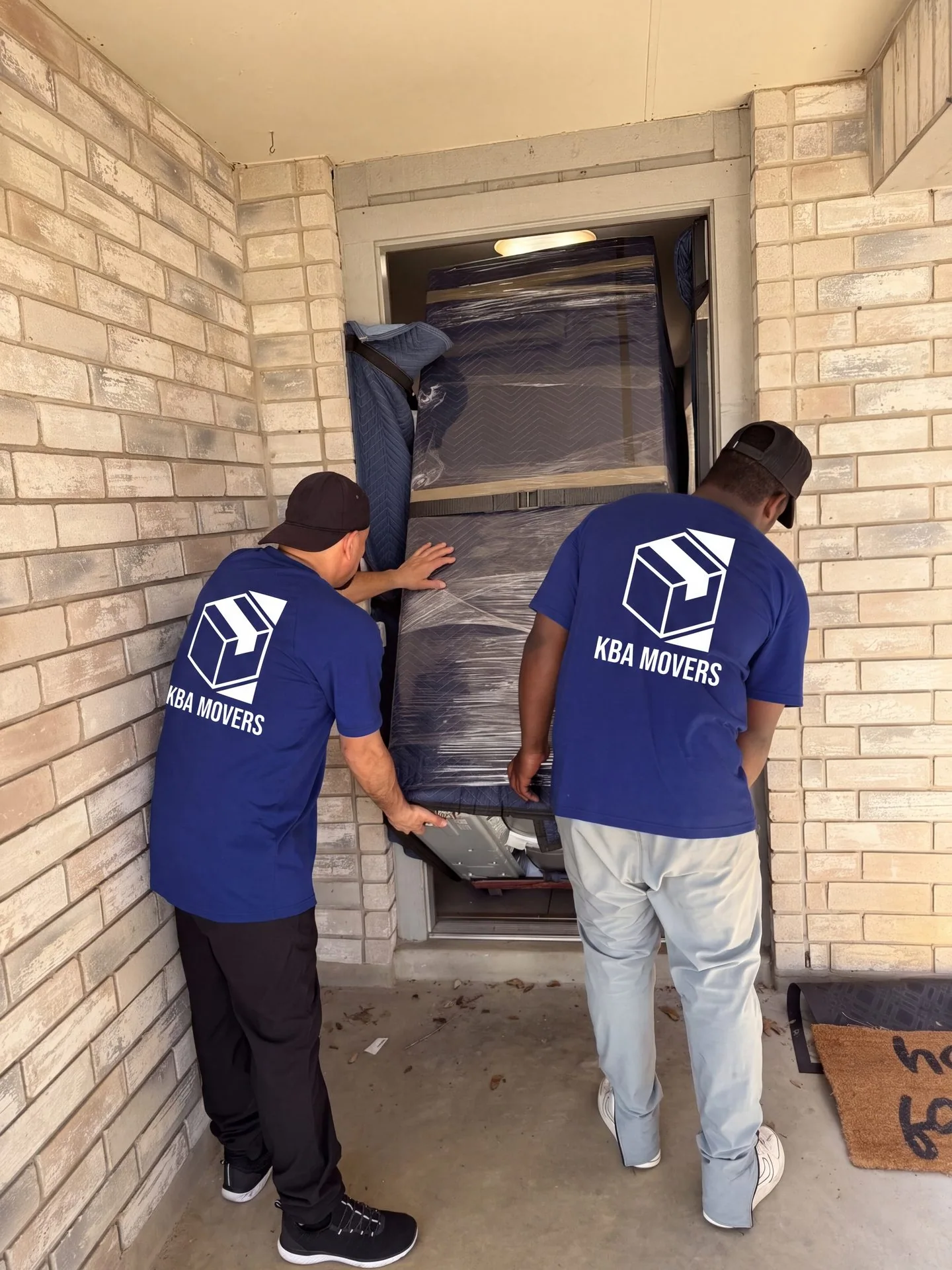 Mover carrying a packed carton out through a doorway