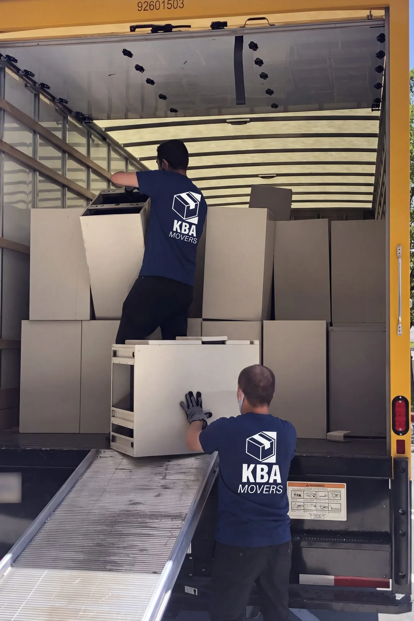 Movers loading office cabinets into a packed box truck