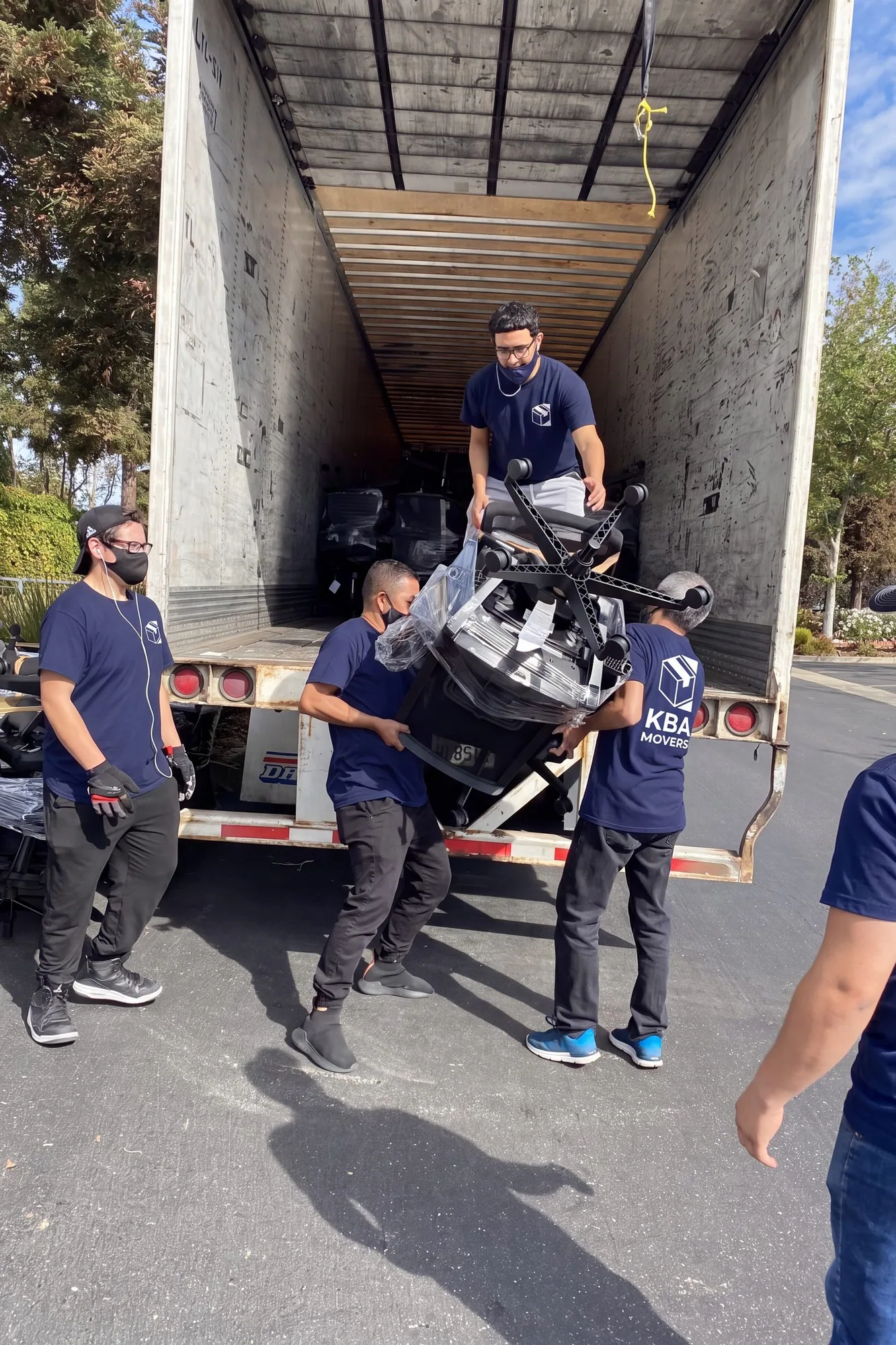 Crew loading a motorcycle up the ramp into a moving truck