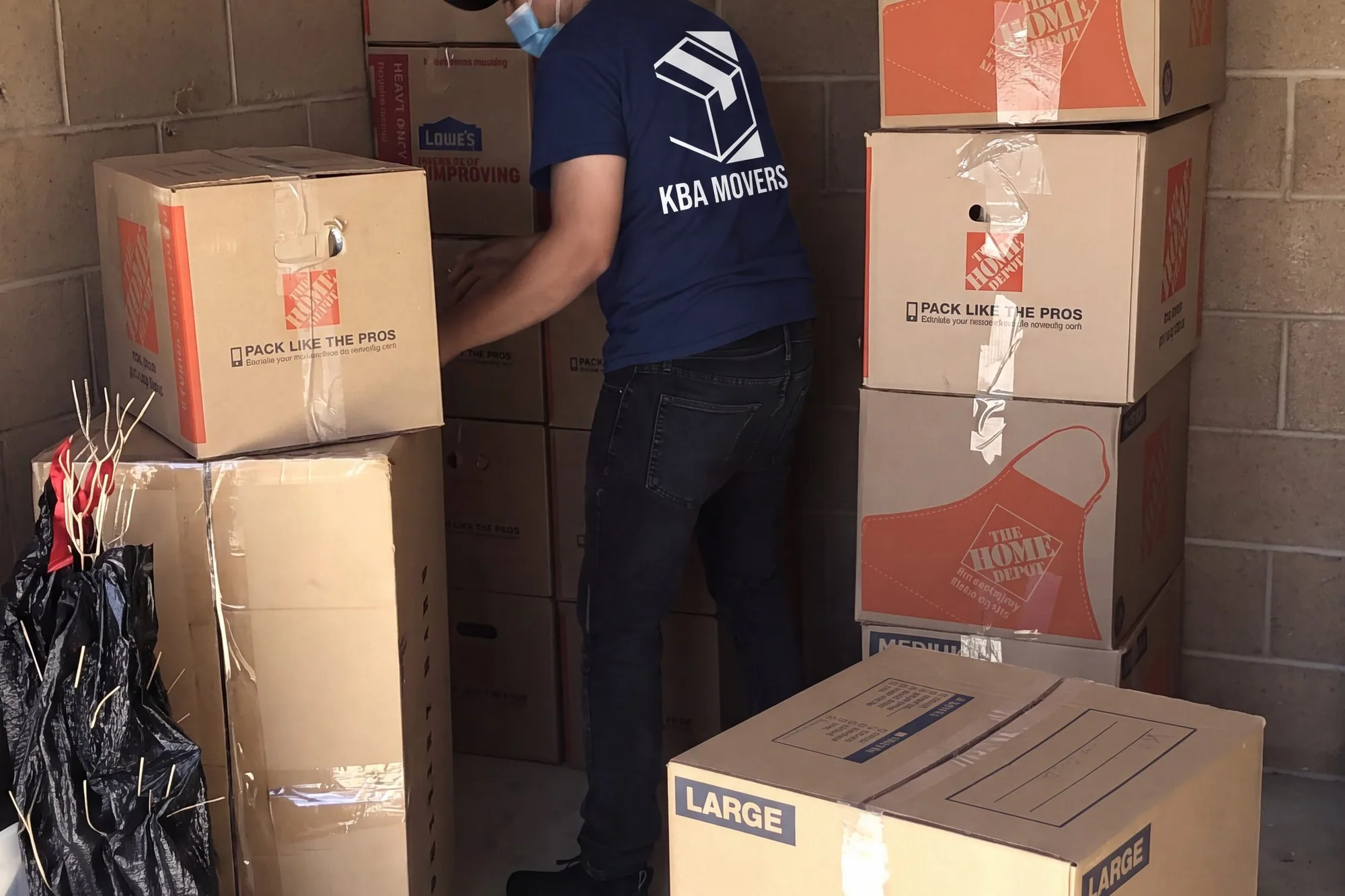 Packed cartons stacked and sorted against a wall during a downsizing
