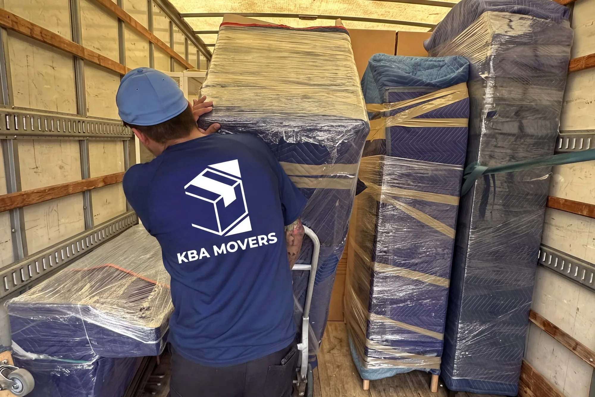 Wrapped furniture and mattresses secured inside a moving truck